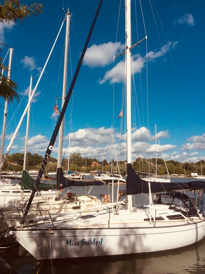 White sail boat docked in the daytime in the dock
